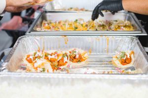 Trays of tacos being served at a wedding party, with attention to details.