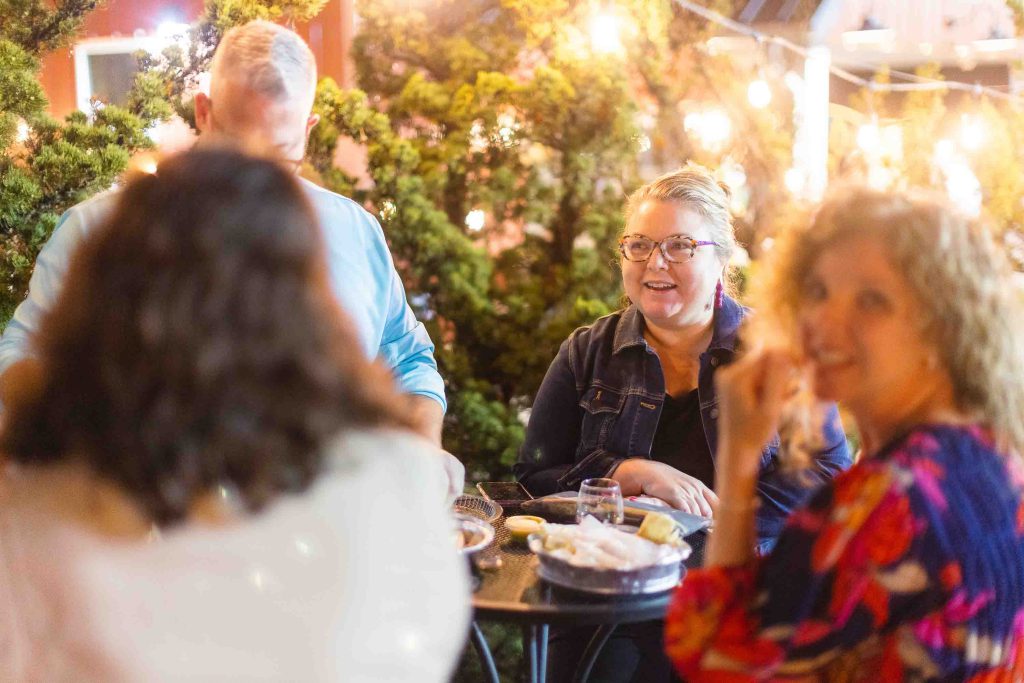 A group of people celebrating a quinceanera at an outdoor table.