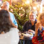 A group of people celebrating a quinceanera at an outdoor table.