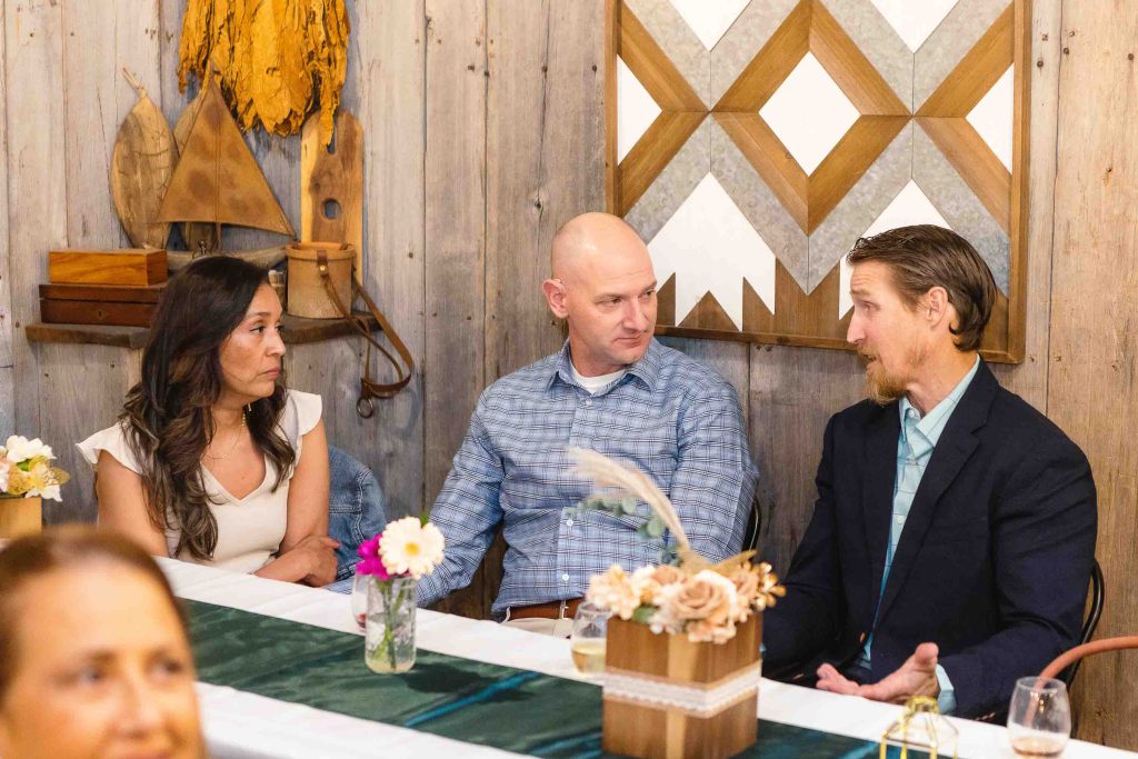 A group of people celebrating a quinceañera sitting around a table.