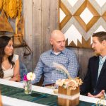 A group of people celebrating a quinceañera sitting around a table.