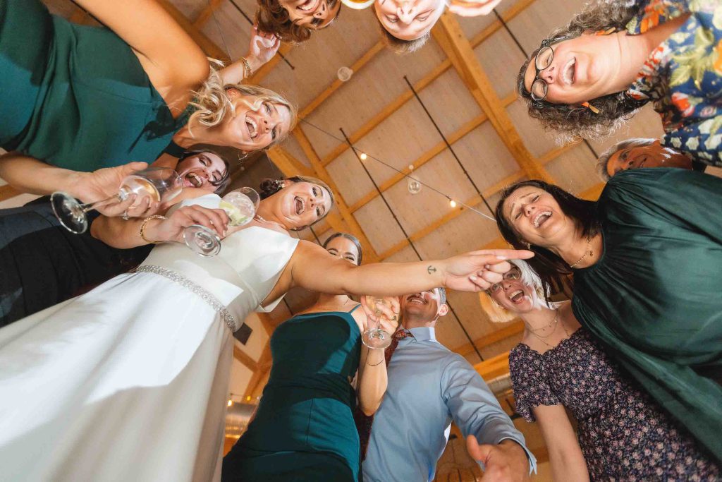 Wedding party poses for group photo at reception.