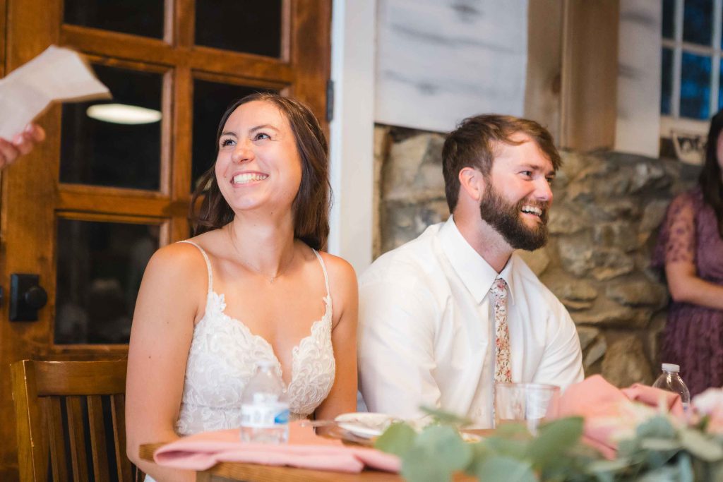 A bride and groom share a lighthearted moment during their wedding reception.