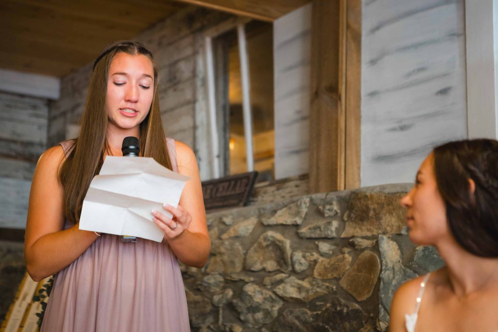 A woman is giving a speech during a wedding reception.