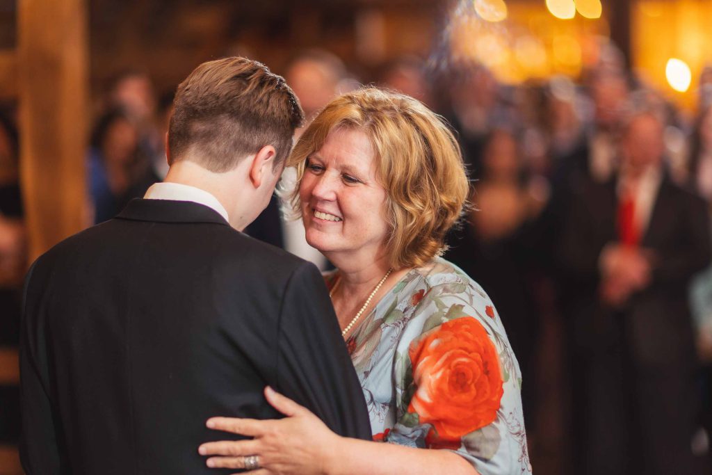 A woman is hugging her mother at a wedding reception.
