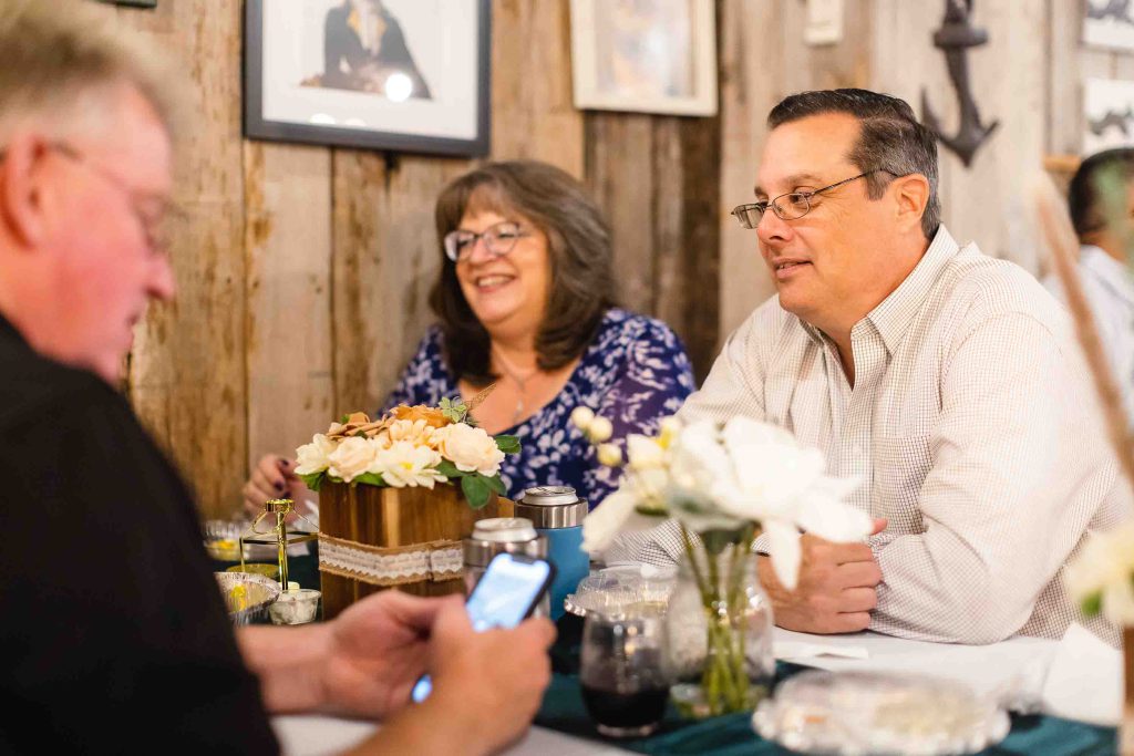 A group of people sitting at a birthday party table with a cell phone.