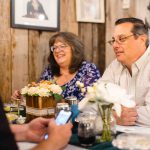 A group of people sitting at a birthday party table with a cell phone.