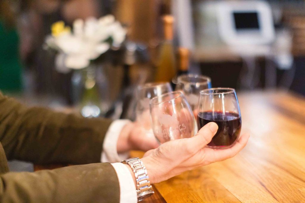 A man holding a glass of wine at a birthday party.