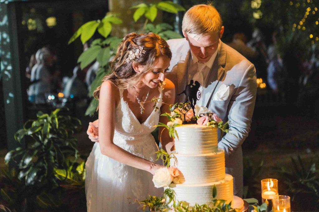 A bride and groom cutting their wedding cake at their reception.