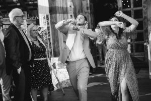 Black and white photo of a group of people dancing at a wedding reception.