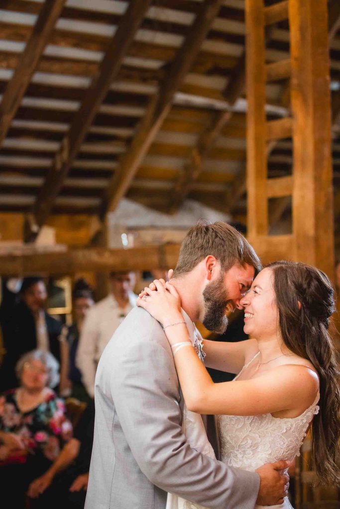 A wedding reception featuring a bride and groom sharing their first dance in a barn.