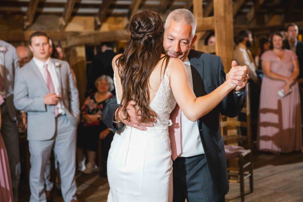 A bride and her father dance at a wedding reception.