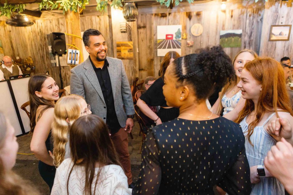 A group of people celebrating at a birthday party in a barn.