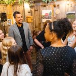 A group of people celebrating at a birthday party in a barn.