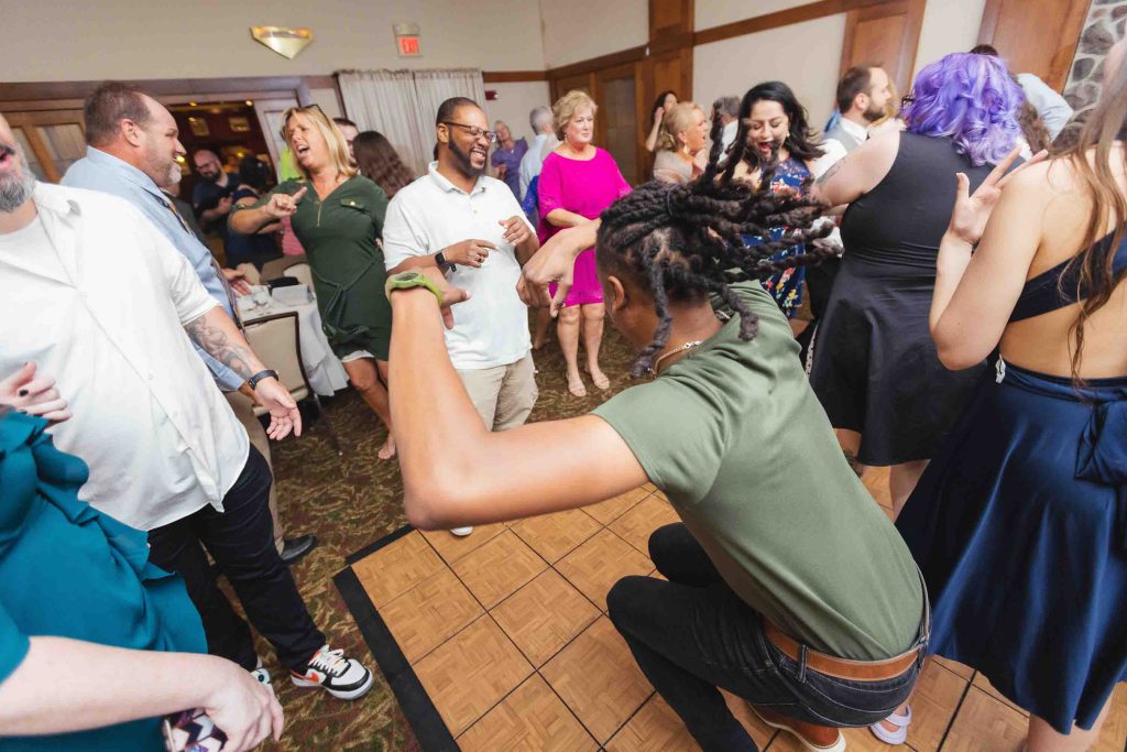 A group of people dancing at a wedding reception.