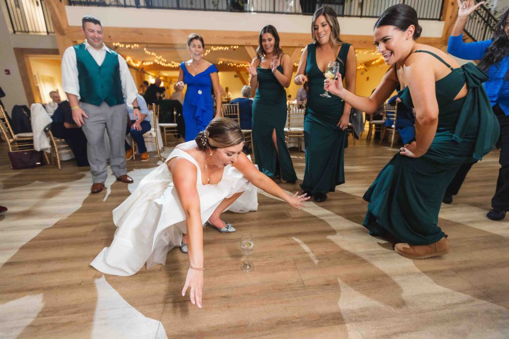 A bride dancing with her bridesmaids at a wedding reception. (Keywords: Reception, Wedding)