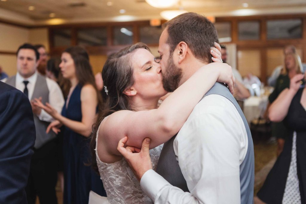 A couple sharing a kiss at their wedding reception.