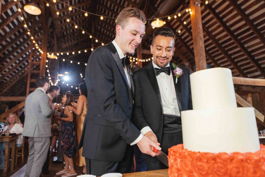 Two men celebrating a wedding reception in a barn.