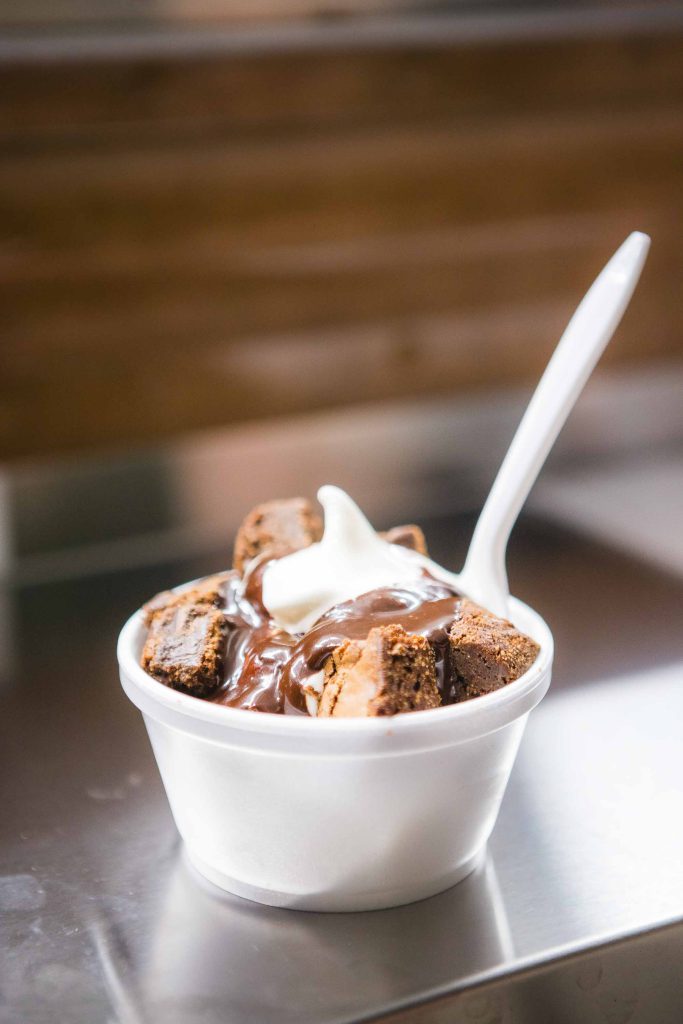 A wedding dessert featuring a bowl of brownies with whipped cream on top.