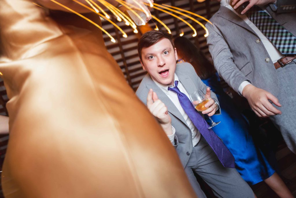 A group of people at a wedding reception with sparklers in their hands.