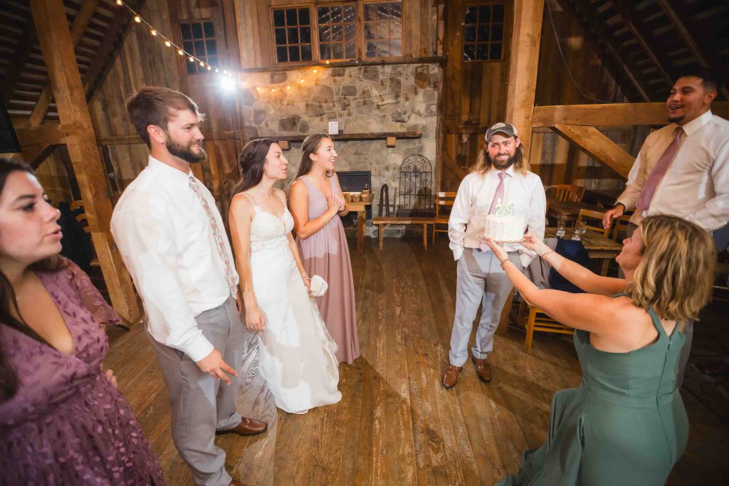 Keywords used: Reception, Wedding

Description: A couple cutting a wedding cake during their reception in a rustic barn.