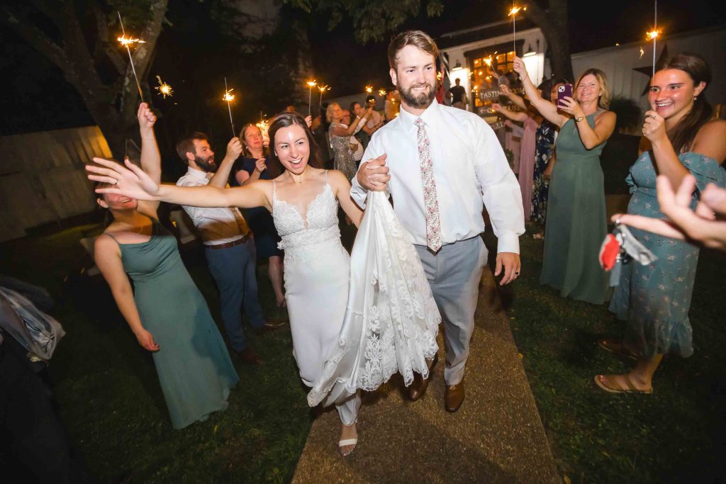 A bride and groom depart from their wedding reception.