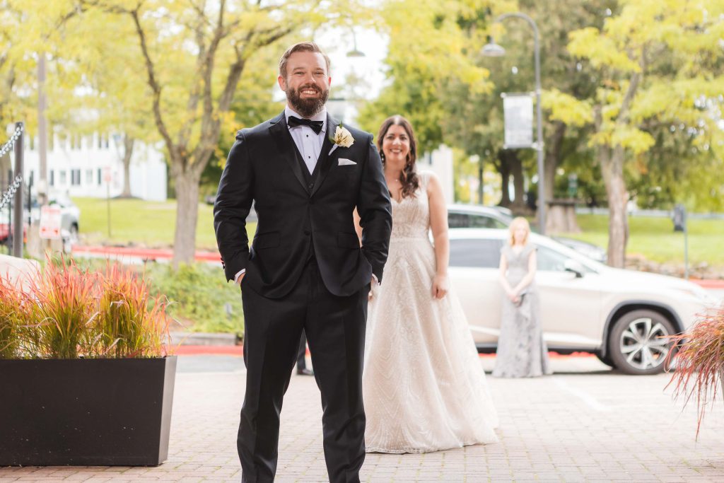 A man in a tuxedo walks down the street towards the Great Room at Savage Mill, where a wedding pre-ceremony is about to take place.