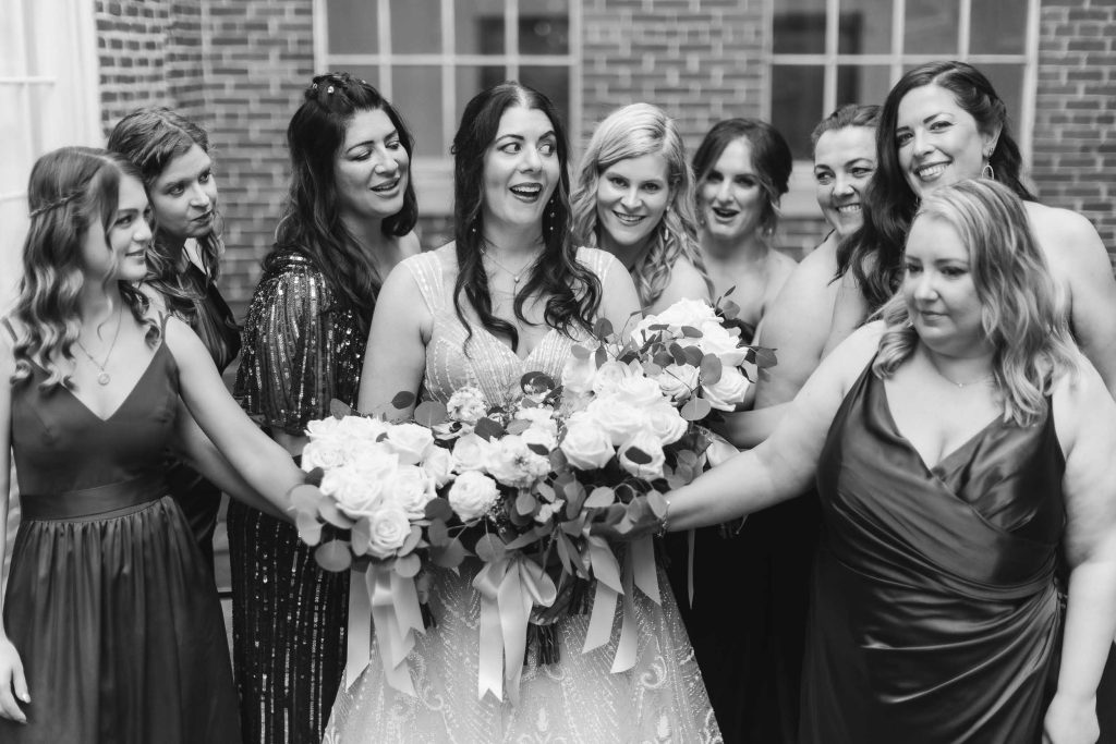 A black and white wedding portrait of a bride and her bridesmaids at Savage Mill.