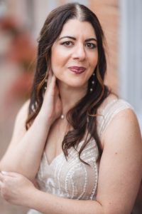 A bride in a white dress is posing for a wedding portrait at Savage Mill.