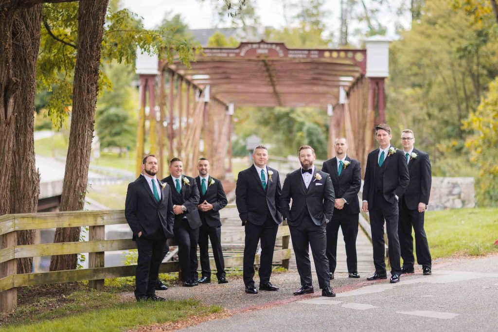 A group of groomsmen standing in front of a wedding venue.