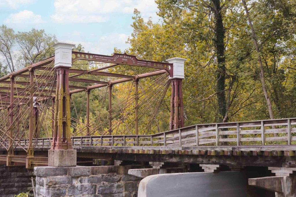 A picturesque old bridge, covered in rust and spanning gracefully over a serene river.