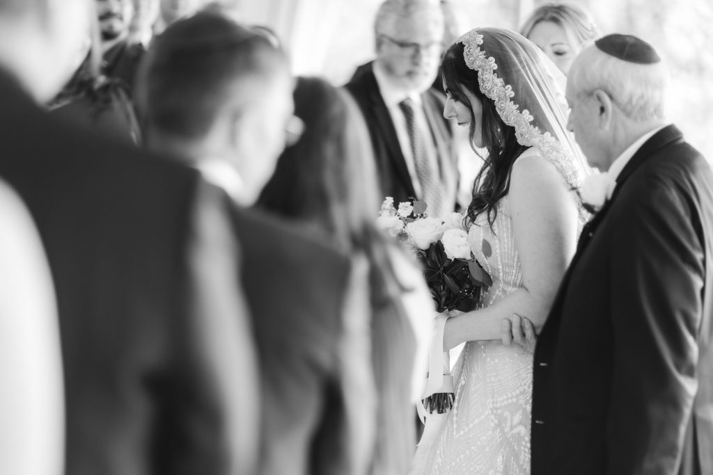 A bride and groom exchange heartfelt glances during their Savage Mill wedding ceremony.