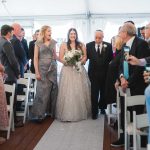 Description: A bride and groom having their wedding ceremony in a tent at Savage Mill.