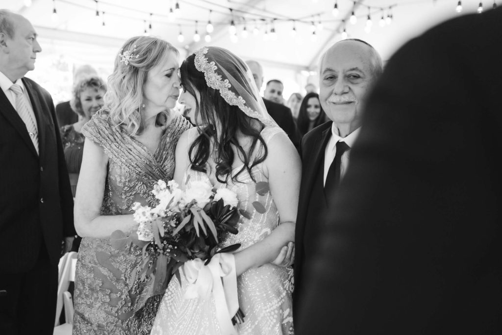 A bride kisses her father during a Savage Mill wedding ceremony.
