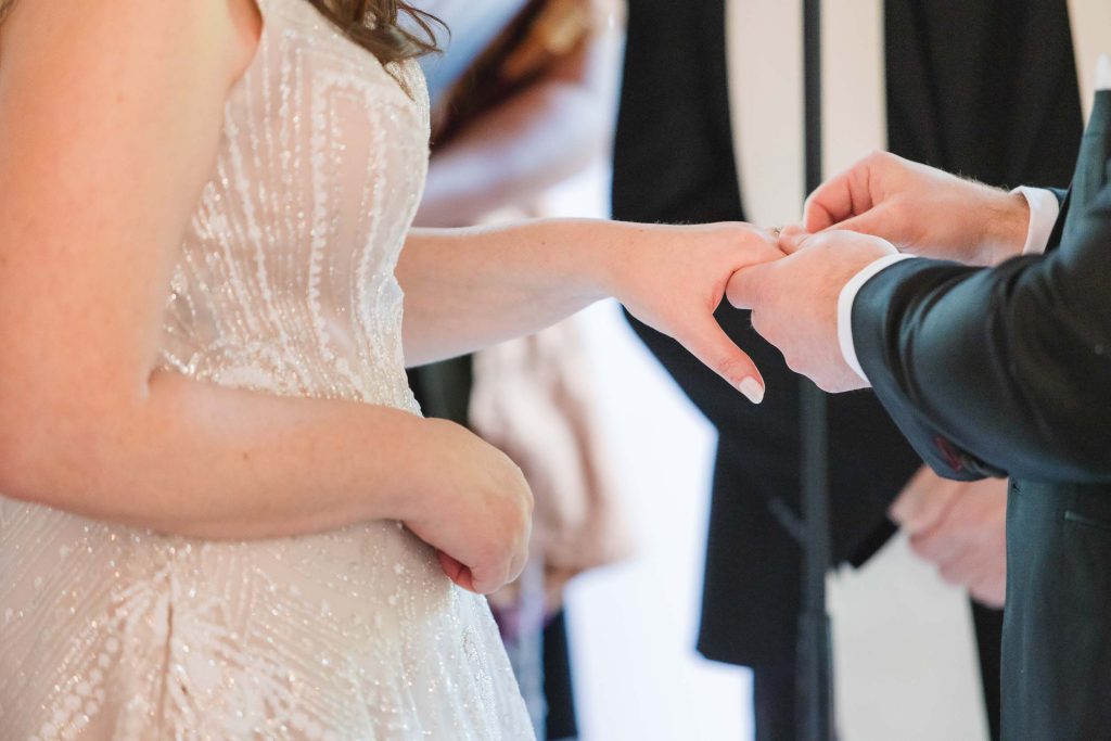 A wedding ceremony at Savage Mill, with the bride and groom exchanging their wedding rings.