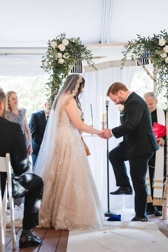 A bride and groom standing under a tent during a Savage Mill wedding ceremony.