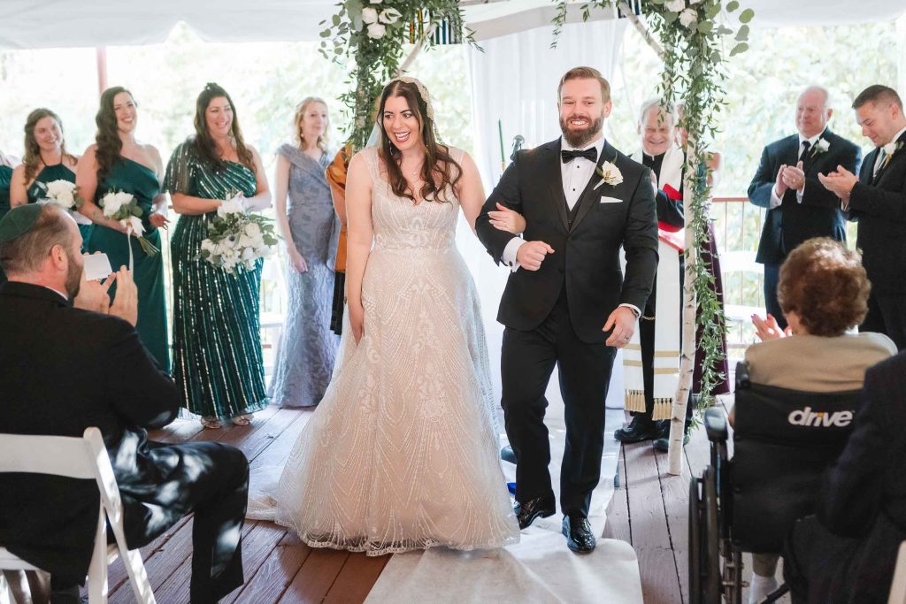 A bride and groom walking down the aisle at their Savage Mill wedding ceremony.