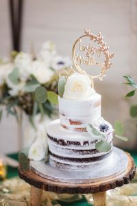 A wedding cake with a happy mother cake topper at Savage Mill.