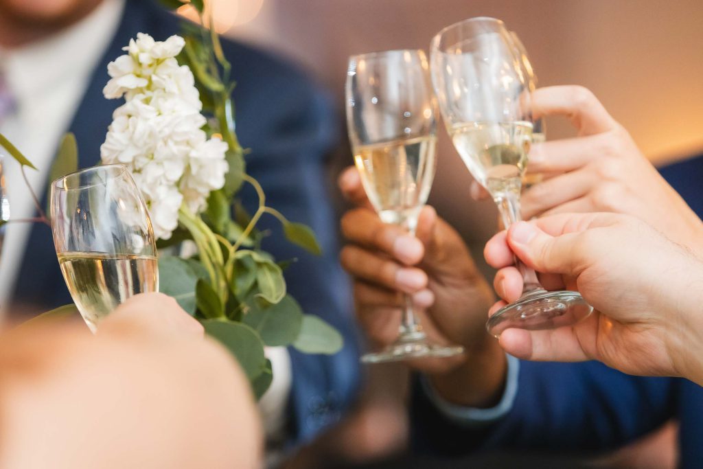 A group of people toasting champagne glasses at a wedding reception.