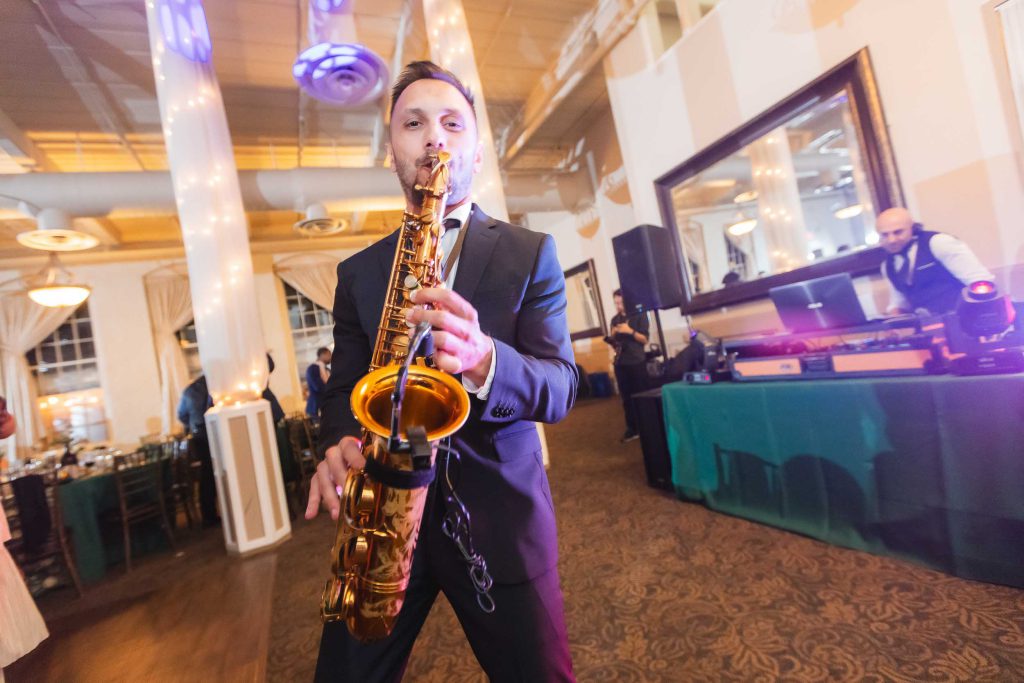 A man playing a saxophone at a wedding reception at Savage Mill.