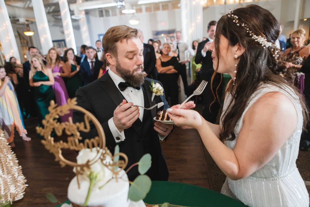 Savage Mill wedding reception featuring a bride and groom feeding each other their wedding cake.