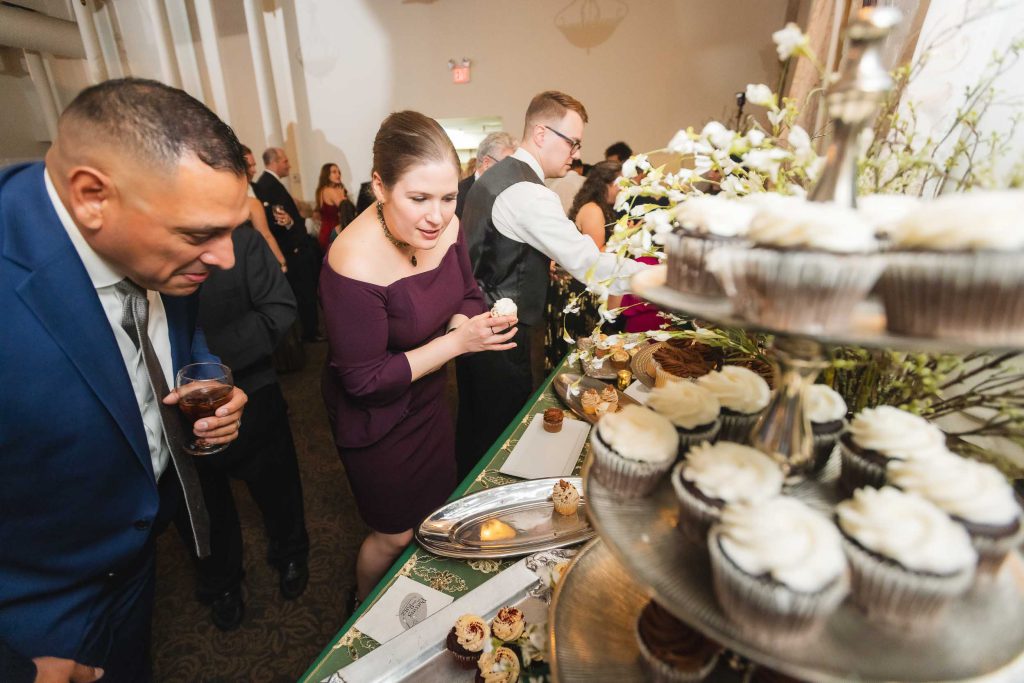 A man and woman looking at cupcakes at a wedding reception held at Savage Mill.