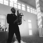 A man playing a saxophone at a wedding reception at Savage Mill.