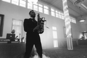 A man playing a saxophone at a wedding reception at Savage Mill.
