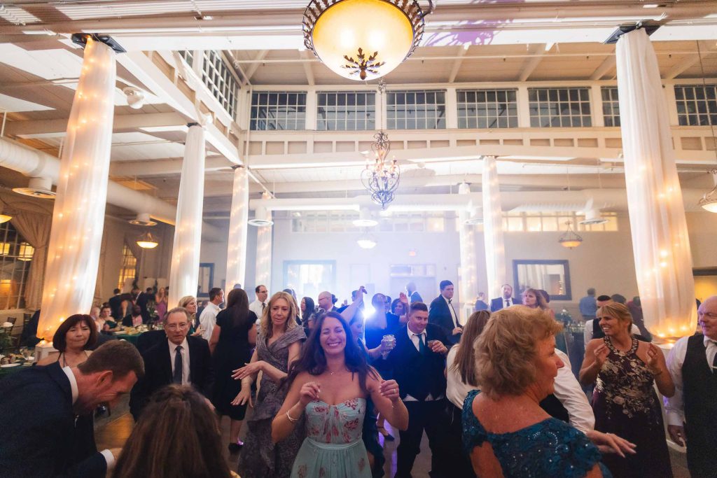 A group of people dancing at a wedding reception held at Savage Mill.