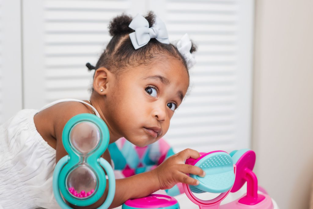 A little girl is playing with a toy in her family home.