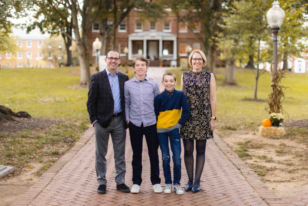 A family posing for a portrait in front of a brick house in Downtown Annapolis.