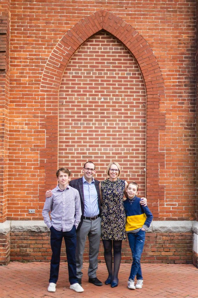 A family posing in front of a downtown Annapolis building for their portraits.