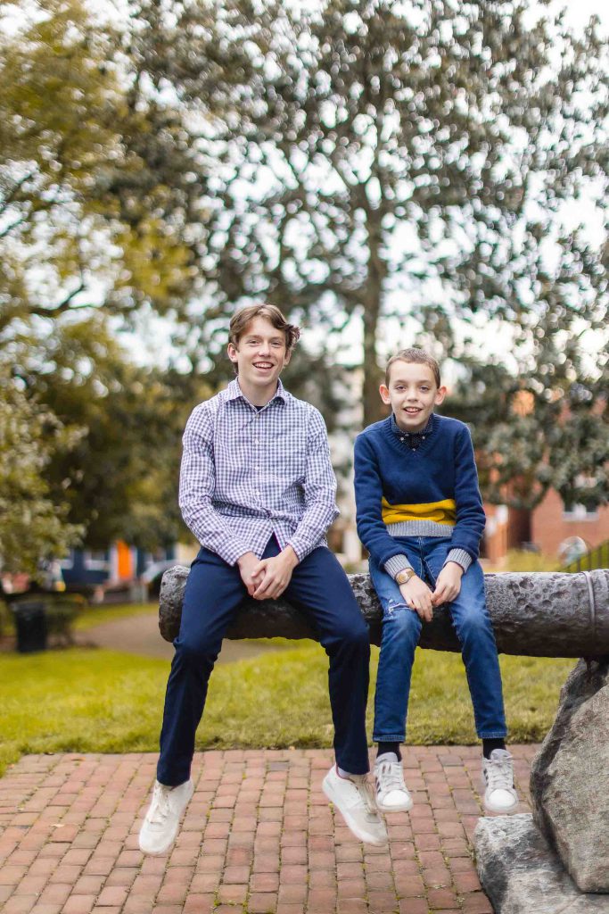 Two boys sitting on a wooden bench in Downtown Annapolis.