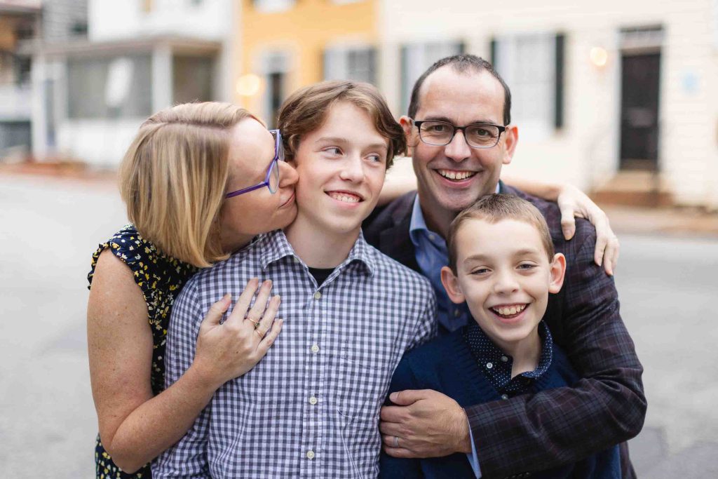 A family is posing for a portrait in front of a house in Downtown Annapolis.